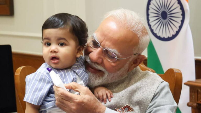PM Modi की गोद में कौन है ये प्याारा बच्चा? जिसे प्रधानमंत्री ने बताया अपना ‘नन्हा दोस्त’, फोटो वायरल | PM Modi’s Viral Photo with Little Boy Omy: Who Is Prime Minister’s ‘Young Friend?